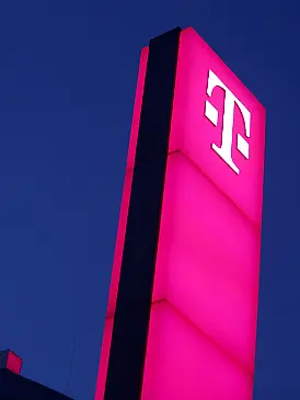 Das Logo der Deutschen Telekom leuchtet auf dem Dach der Unternehmenszentrale.