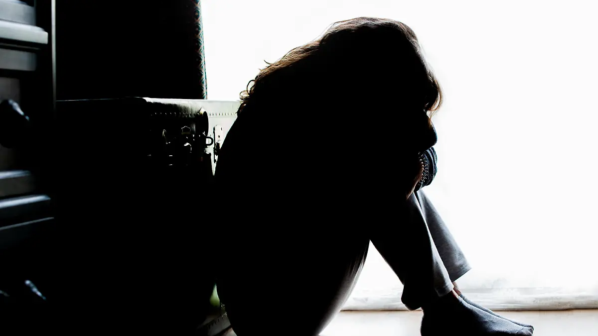 Unhappy mature lady, woman in silhouette, sitting on the floor with back lit. Depressing thoughts. || Modellfreigabe vorhanden