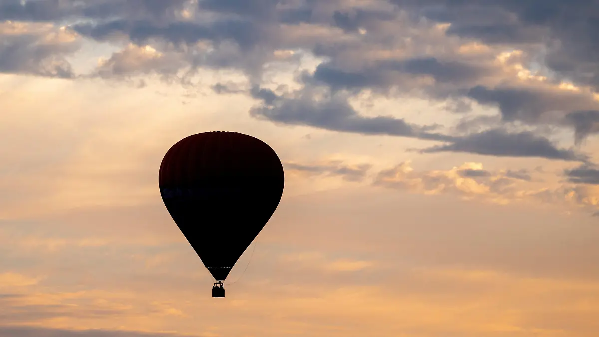 ARCHIV - 22.08.2023, Niedersachsen, Elsfleth: Ein Heißluftballon fährt am frühen Morgen vor dem leicht bewölkten Himmel über den Feldern und Wiesen in der Wesermarsch. -  Ein Teilnehmer einer Ballonfahrt ist in einem Vorort von Melbourne aus dem Korb in den Tod gestürzt. (zu dpa: «Mann stürzt in Australien aus Heißluftballon in den Tod») Foto: Hauke-Christian Dittrich/dpa +++ dpa-Bildfunk +++