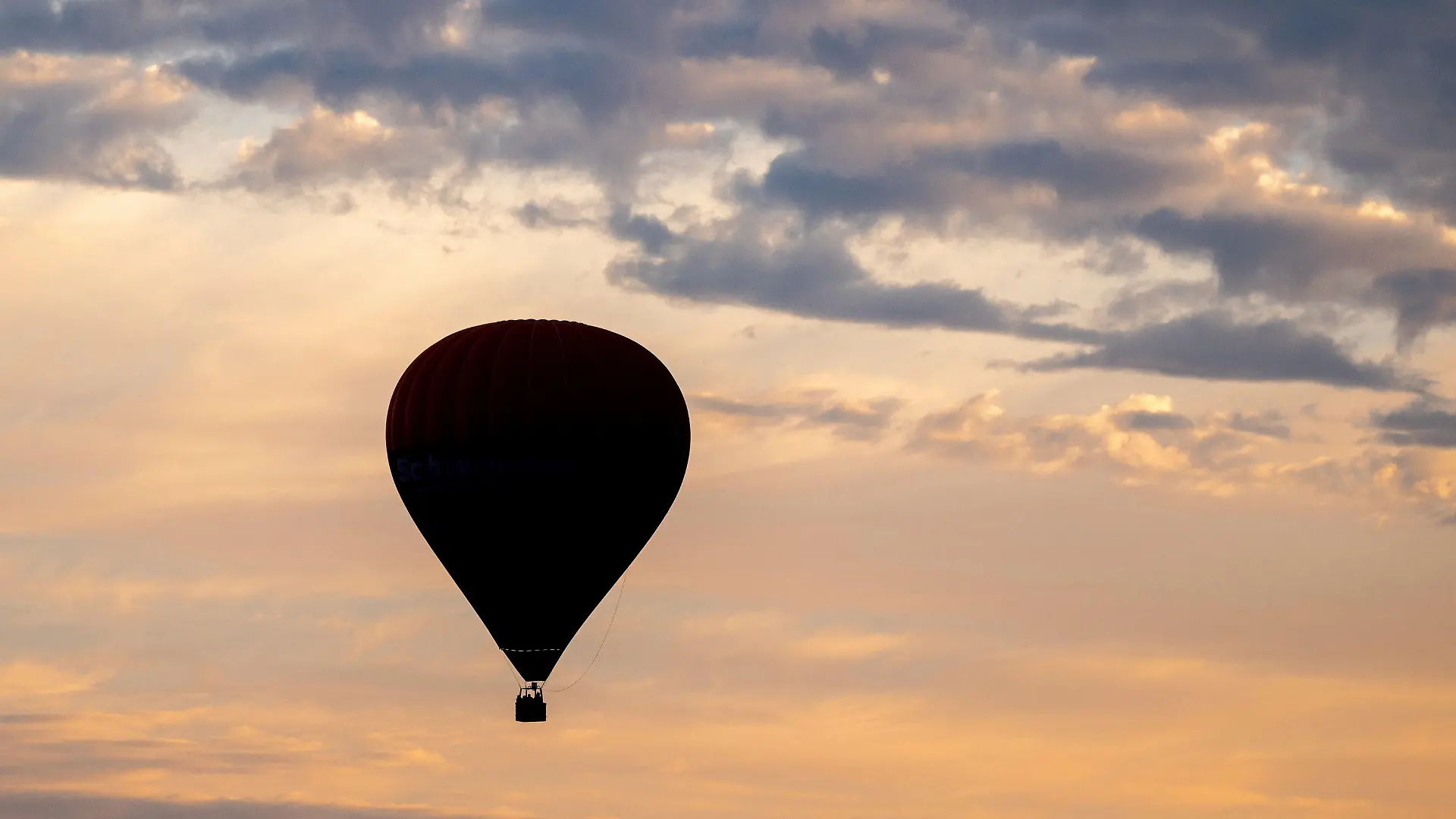 ARCHIV - 22.08.2023, Niedersachsen, Elsfleth: Ein Heißluftballon fährt am frühen Morgen vor dem leicht bewölkten Himmel über den Feldern und Wiesen in der Wesermarsch. -  Ein Teilnehmer einer Ballonfahrt ist in einem Vorort von Melbourne aus dem Korb in den Tod gestürzt. (zu dpa: «Mann stürzt in Australien aus Heißluftballon in den Tod») Foto: Hauke-Christian Dittrich/dpa +++ dpa-Bildfunk +++