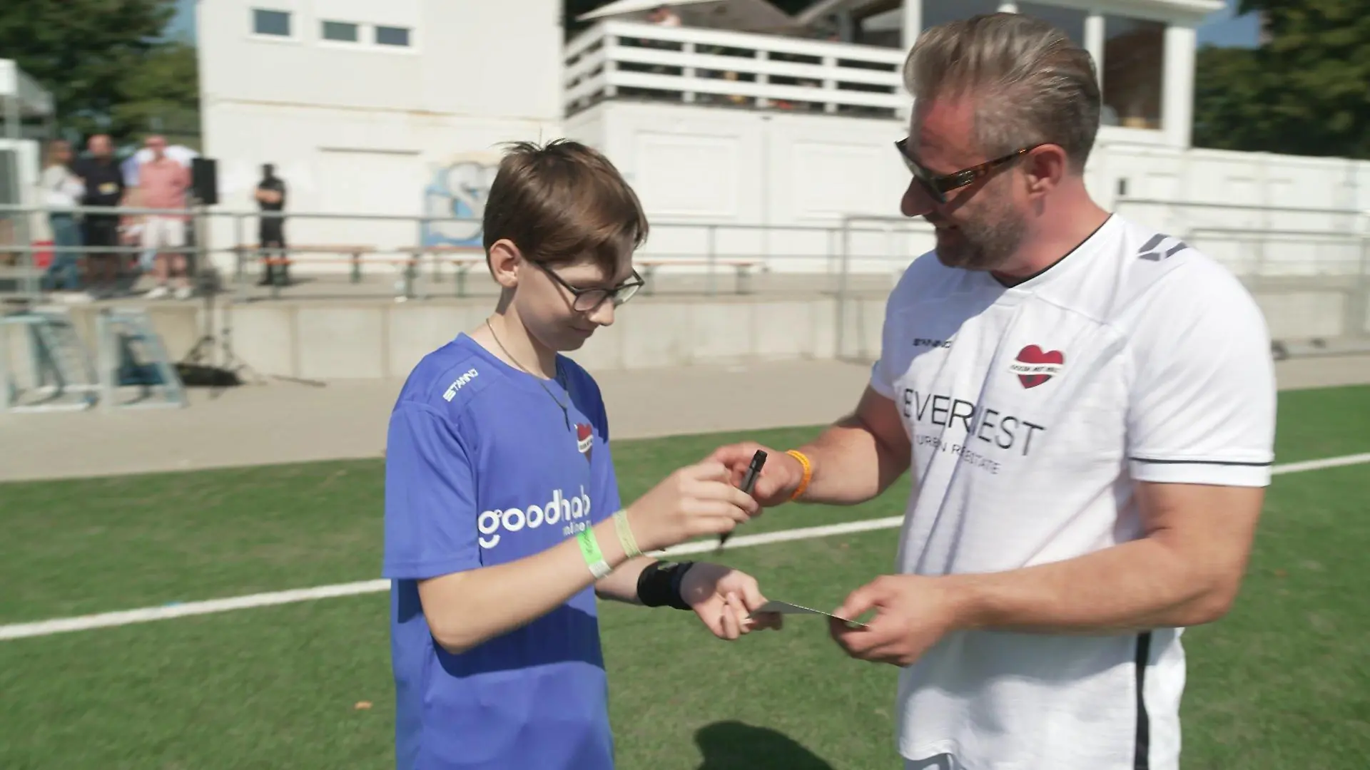 Sänger Sasha gibt beim "Kicken mit Herz " fleißig Autogramme.
