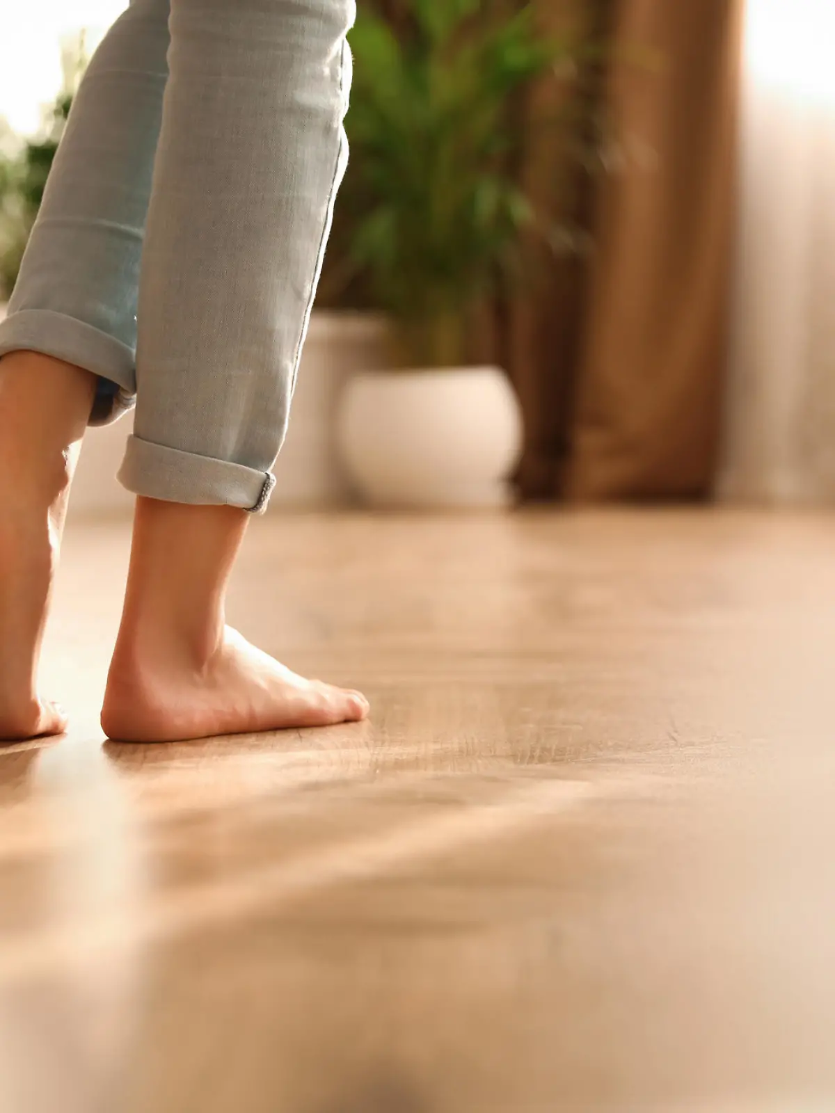 Barefoot woman at home, closeup. Floor heating system