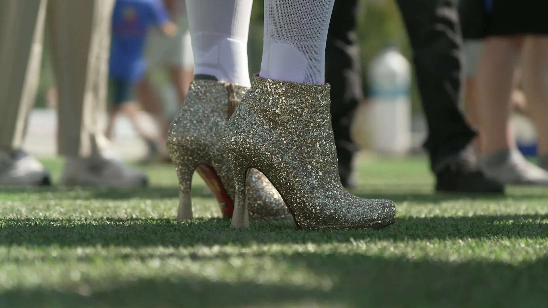 Jorge González kickt mit High Heels auf dem Fußballfeld.