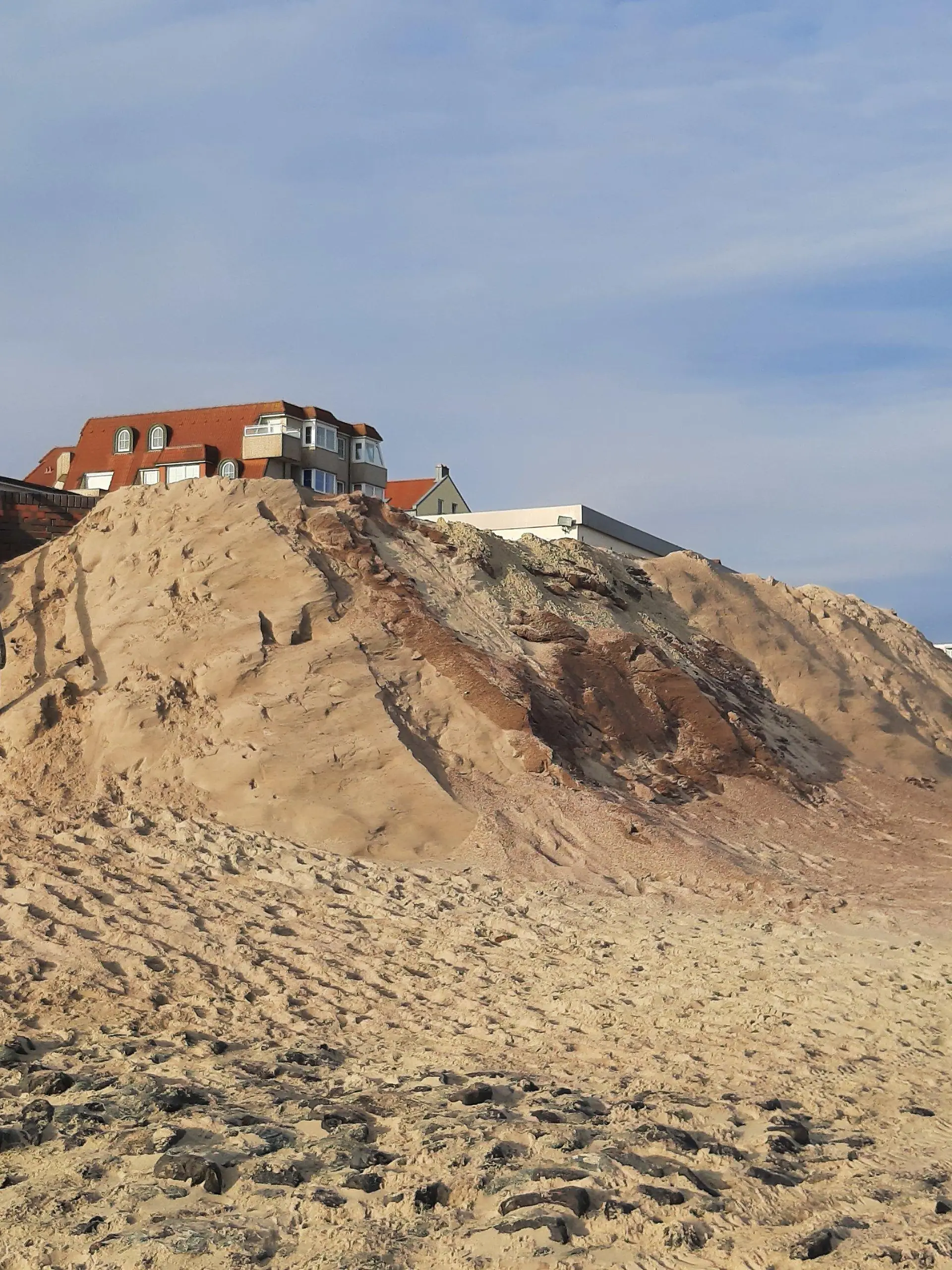 PRODUKTION - 14.03.2024, Niedersachsen, Wangerooge: Ein Mann geht mit einem Hund eine Treppe am Strand der ostfriesischen Insel Wangerooge hinab. Die bisherige Sturmflutsaison hat auf einigen Nordseeinsel deutliche Schäden an den Badestränden angerichtet. (zu dpa «Eine ziemlich Katastrophe» - Inseln fehlen nach Sturmfluten Badestrände") Foto: -/dpa +++ dpa-Bildfunk +++