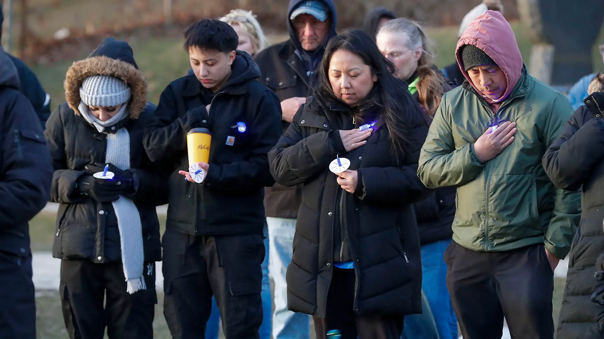 Family and friends of missing 3-year-old Elijah Vue pause during a vigil for him at Walsh Field, Saturday, March 16, 2024, in Two Rivers, Wis. Vue has been missing for more than 25 days. (Gary C. Klein/The Sheboygan Press via AP)