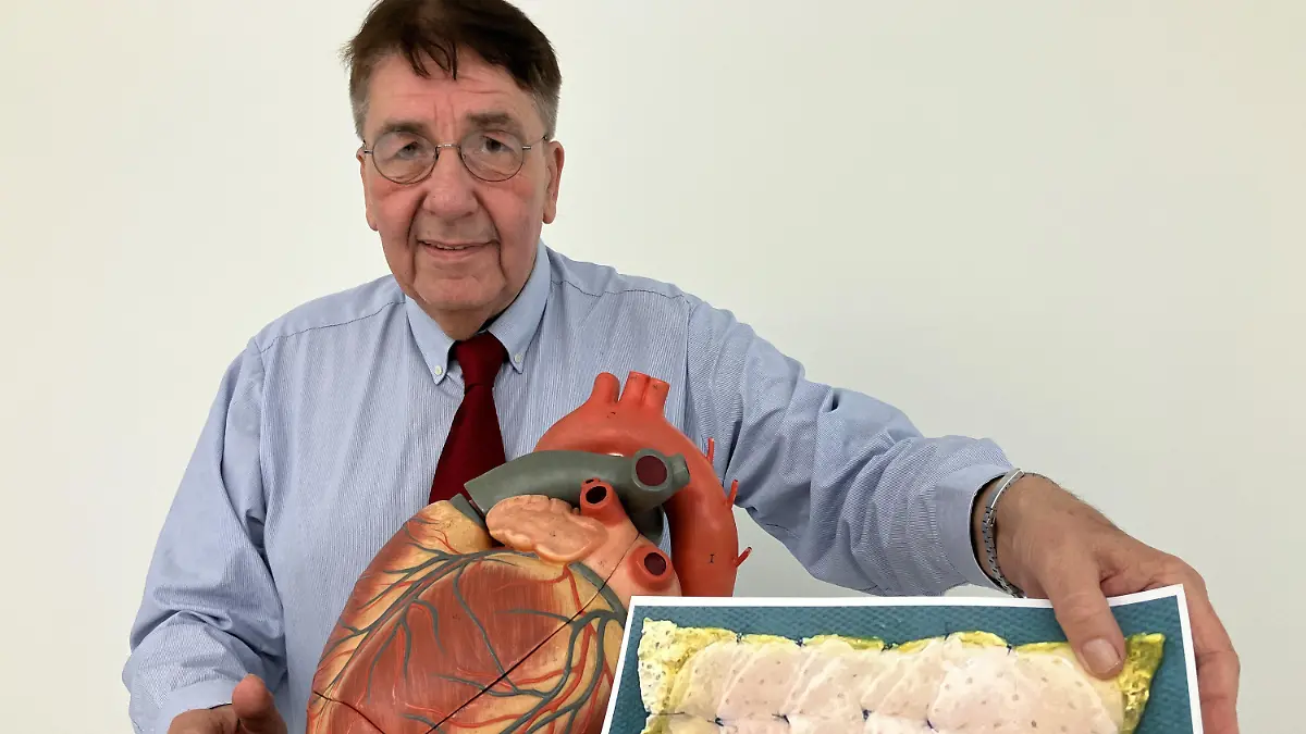 18.03.2024, Niedersachsen, Göttingen: Herzpflaster-Patient Frank Teege steht neben einem Herz-Modell und zeigt ein Bild, auf dem ein Herzpflaster zu sehen ist. Zur Behandlung von Herzmuskelschwächen haben Mediziner ein neues Medikament entwickelt. Erste Studienergebnisse des sogenannten Herzpflasters deuten auf dessen Wirksamkeit hin, wie die Wissenschaftler am Montag bei einer Pressekonferenz in Göttingen sagten. Foto: Maurice Arndt/dpa +++ dpa-Bildfunk +++