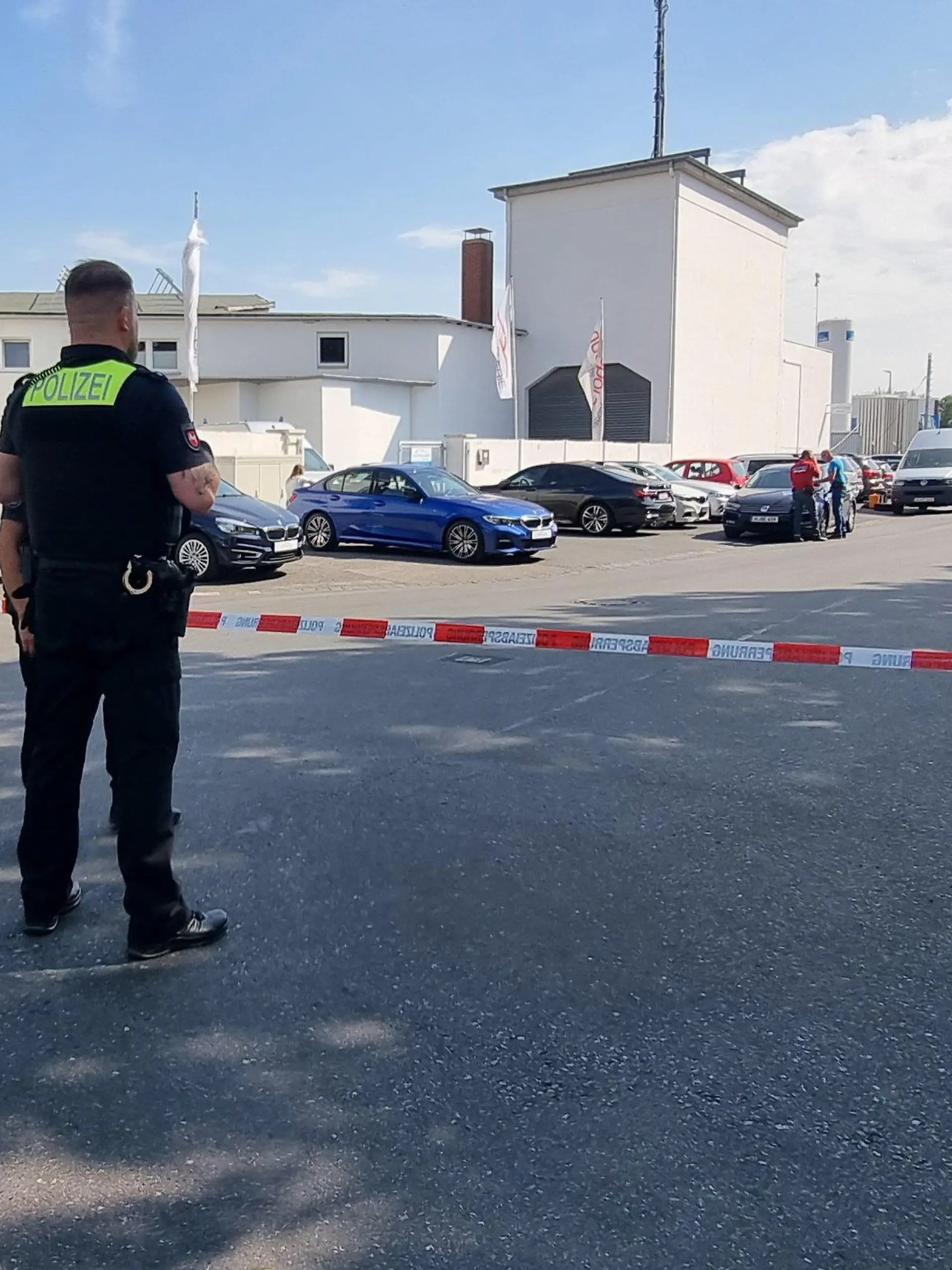 05.09.2022, Hannover: Ein Polizist steht vor einer Absperrung. Zuvor war ein Mann in einer Autowerkstatt in Hannover erschossen worden. (zu dpa: «Mann in Werkstatt erschossen - Polizei nimmt verdächtige Person fest») Foto: -/dpa - ACHTUNG: Verwendung nur im vollen Format +++ dpa-Bildfunk +++