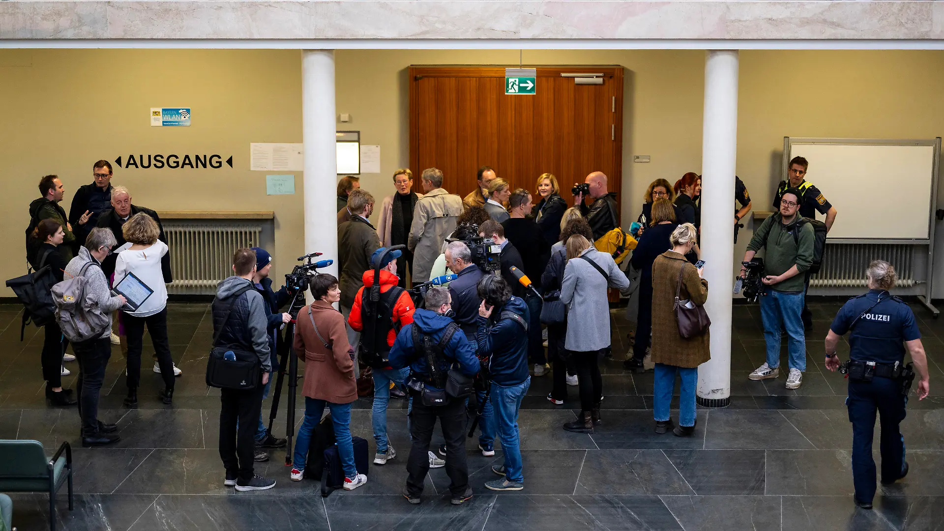 19.03.2024, Bayern, Traunstein: Journalisten und Prozessbesucher warten im Landgericht Traunstein auf Einlass in den Gerichtssaal. Wegen Mordes an der Studentin Hanna hat das Landgericht Traunstein am Dienstag einen 22-Jährigen zu neun Jahren Jugendstrafe verurteilt. Foto: Lennart Preiss/dpa +++ dpa-Bildfunk +++