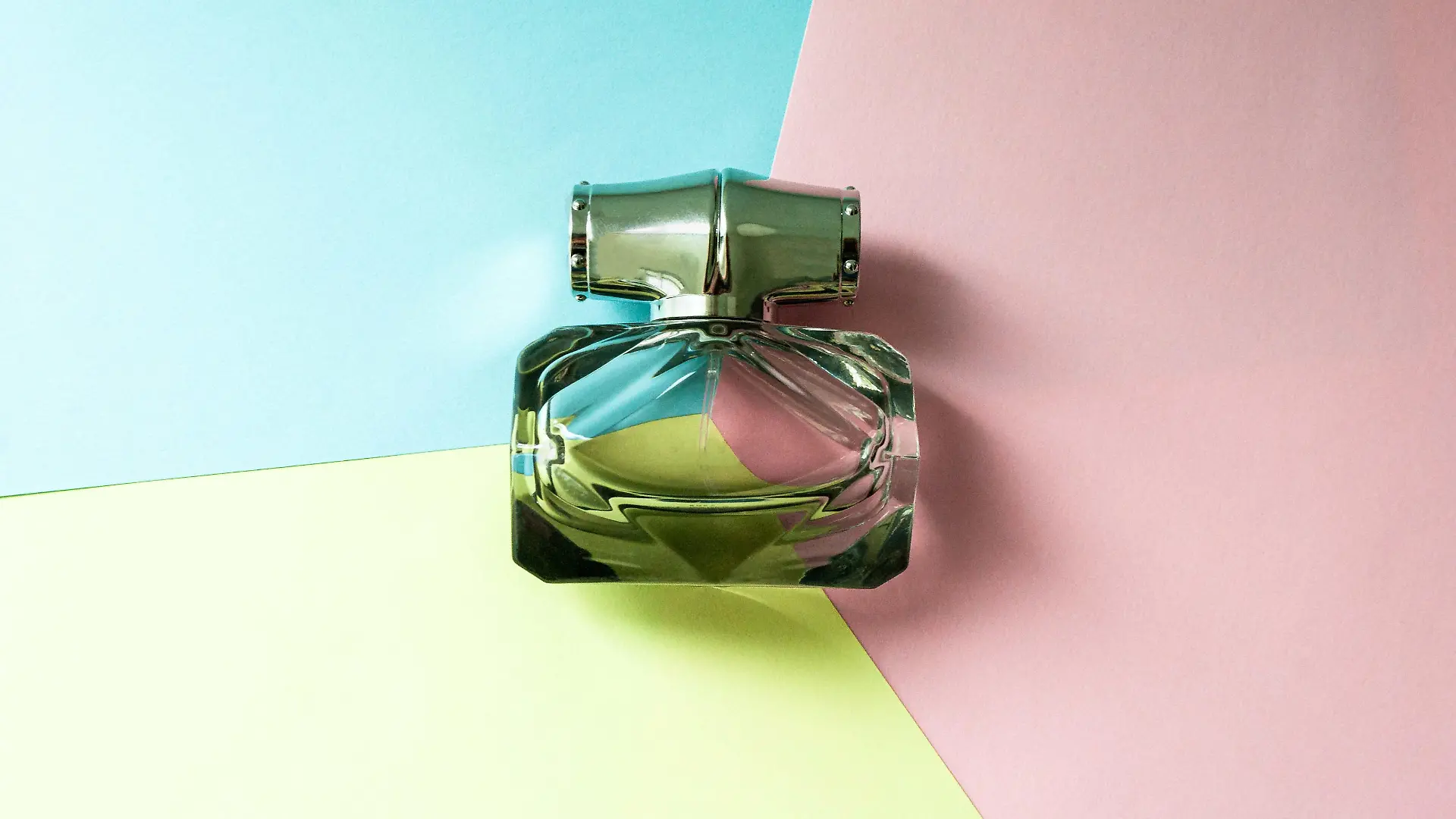 A bottle of eau de toilette on a multi-colored background