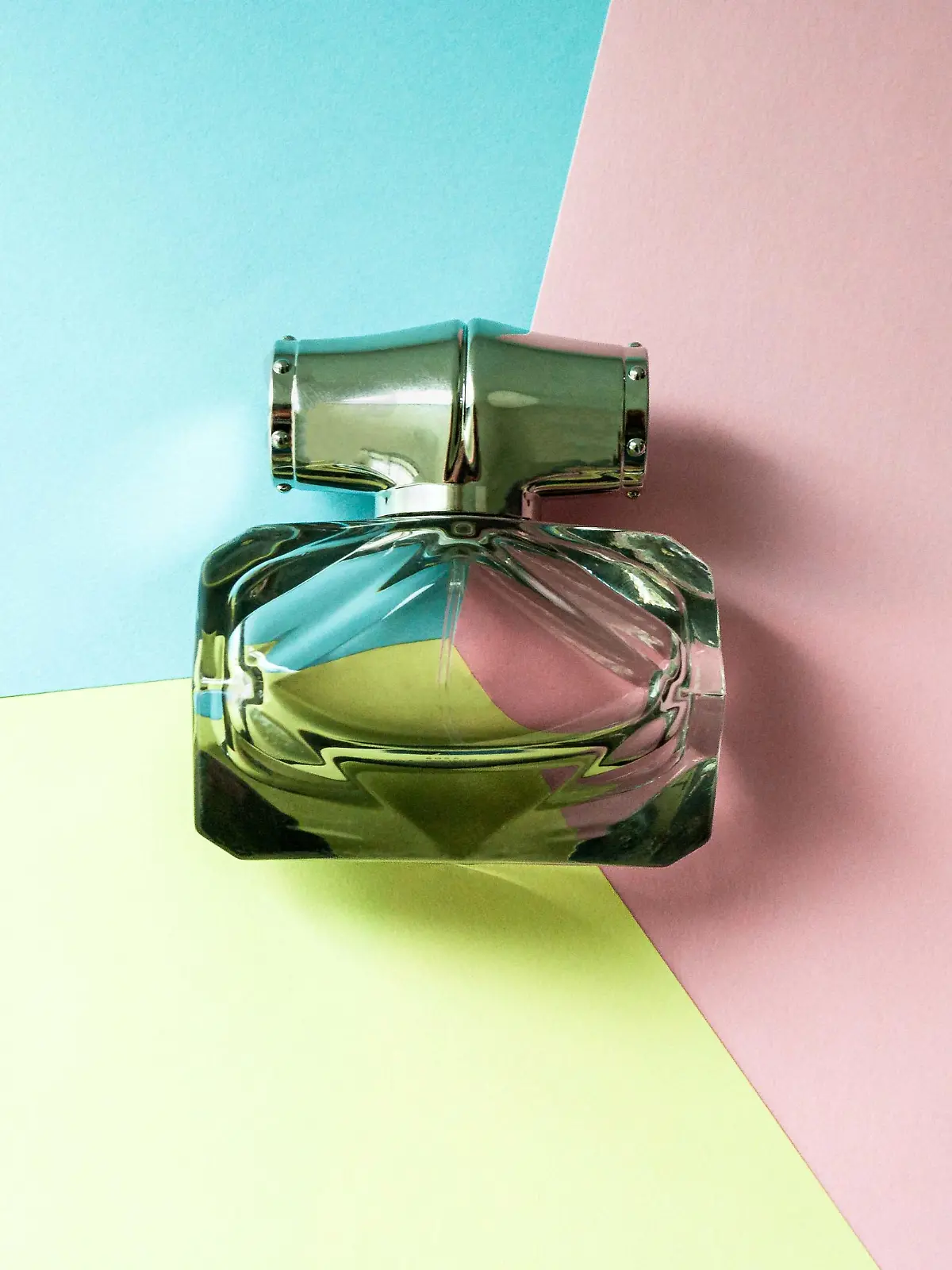 A bottle of eau de toilette on a multi-colored background