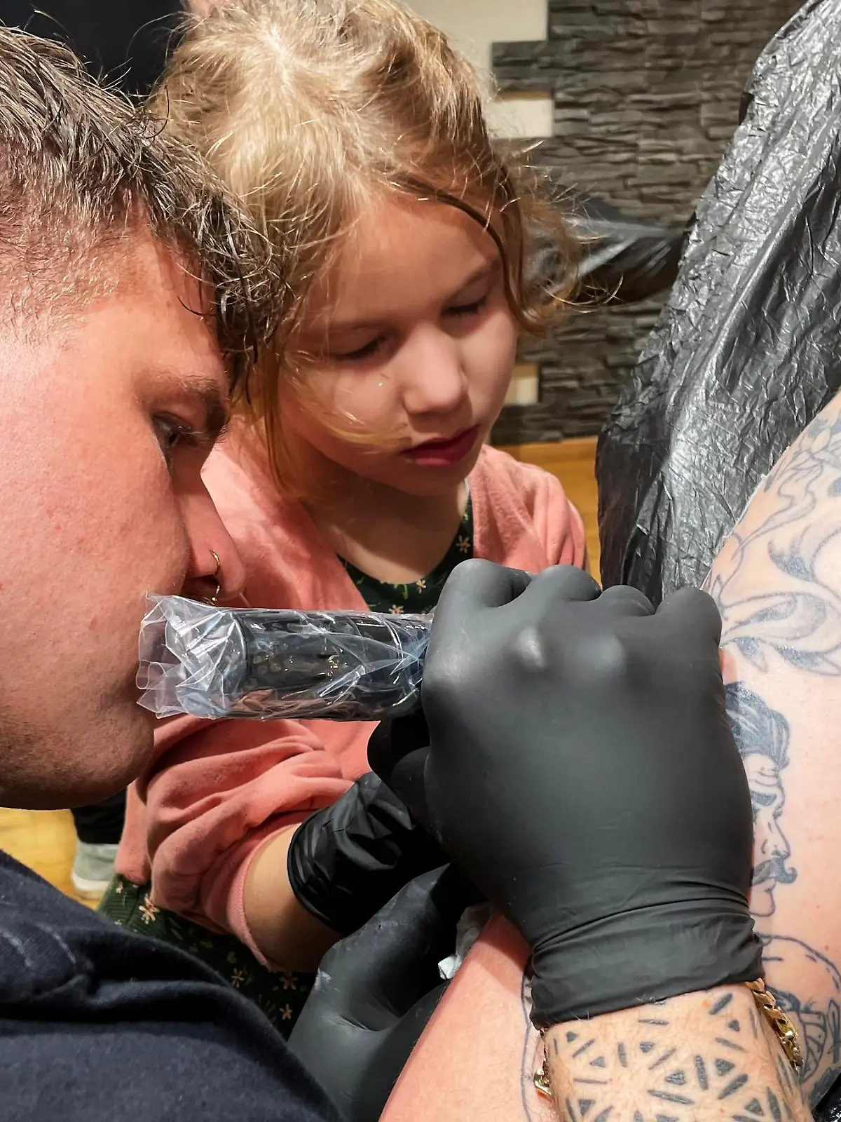 Edda ist erst sechs Jahre alt. Unter der professionellen Anleitung von Tattoo-Artist Jan Wolfsdorf tätowiert sie ihren Vater Christoph.