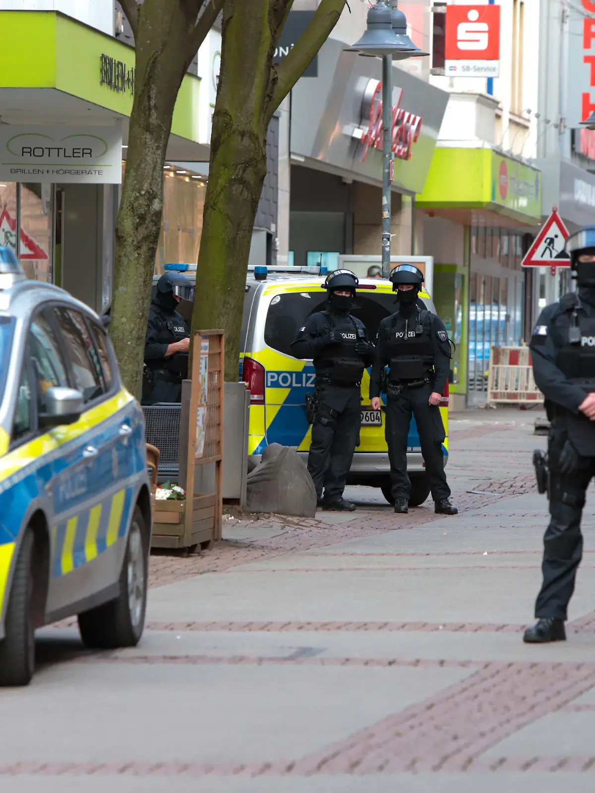 19.03.2024, Nordrhein-Westfalen, Bochum: Einsatzkräfte der Polizei stehen in der Innenstadt von Bochum. In der von der Polizei weiträumig abgesperrten Sparkasse an der Oststraße in Bochum sind nach Angaben der Einsatzkräfte zwei Gegenstände gefunden worden. Foto: Justin Brosch/dpa +++ dpa-Bildfunk +++