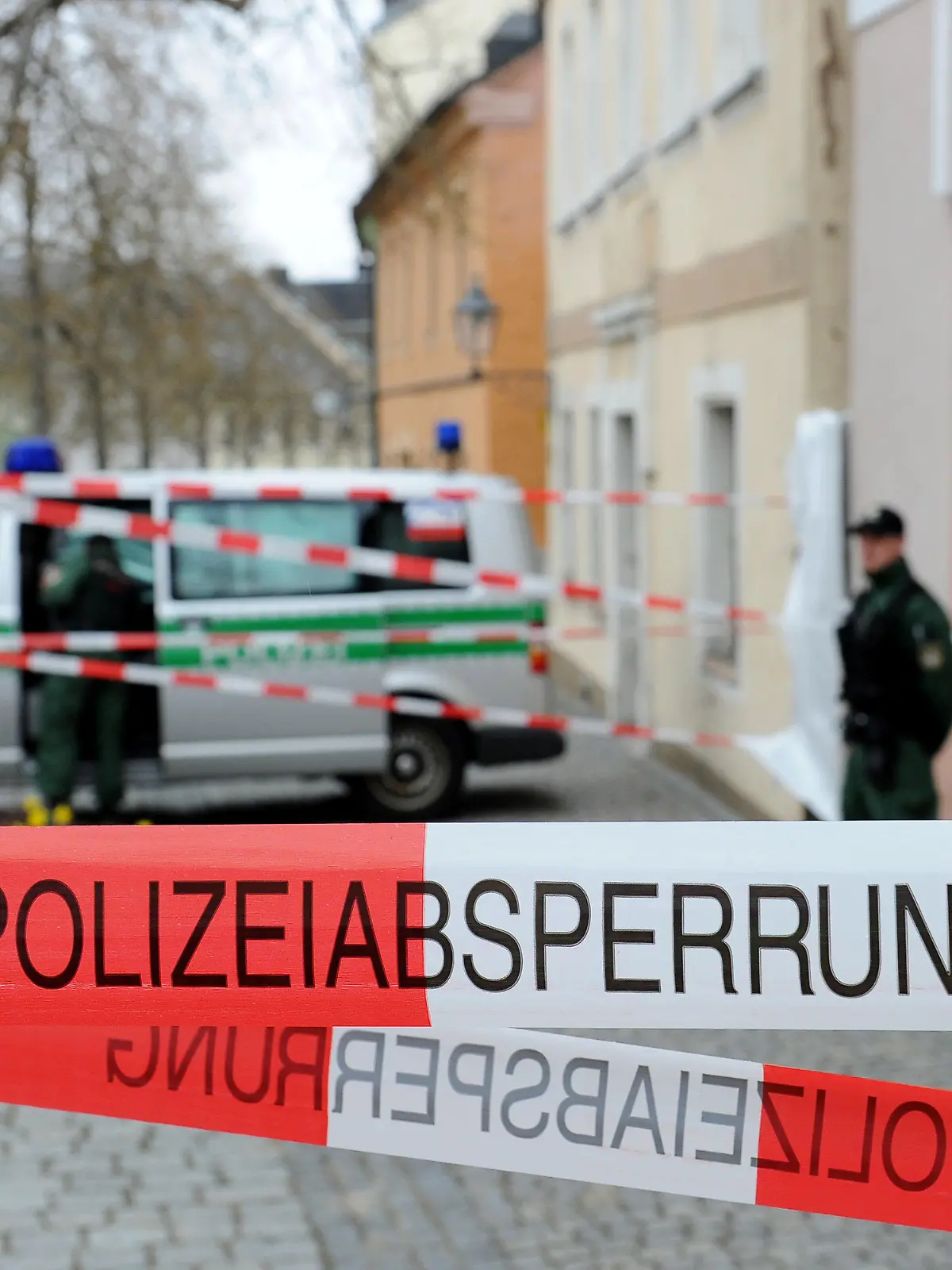 Zwei Polizisten bewachen am 22.04.2013 einen Hauseingang in Lichtenberg (Bayern), in dem die Spurensicherung nach der Leiche des Mädchens «Peggy» sucht. Vor zwölf Jahren verschwand «Peggy» und der geistig behinderte Ulvi K. wurde wegen Mordes verurteilt - nun hat die Polizei Hinweise, wo die Leiche sein könnte. Foto: David Ebener/dpa (zu dpa «Neue Hinweise - Polizei sucht nach Peggys Leiche» vom 22.04.2013) +++(c) dpa - Bildfunk+++