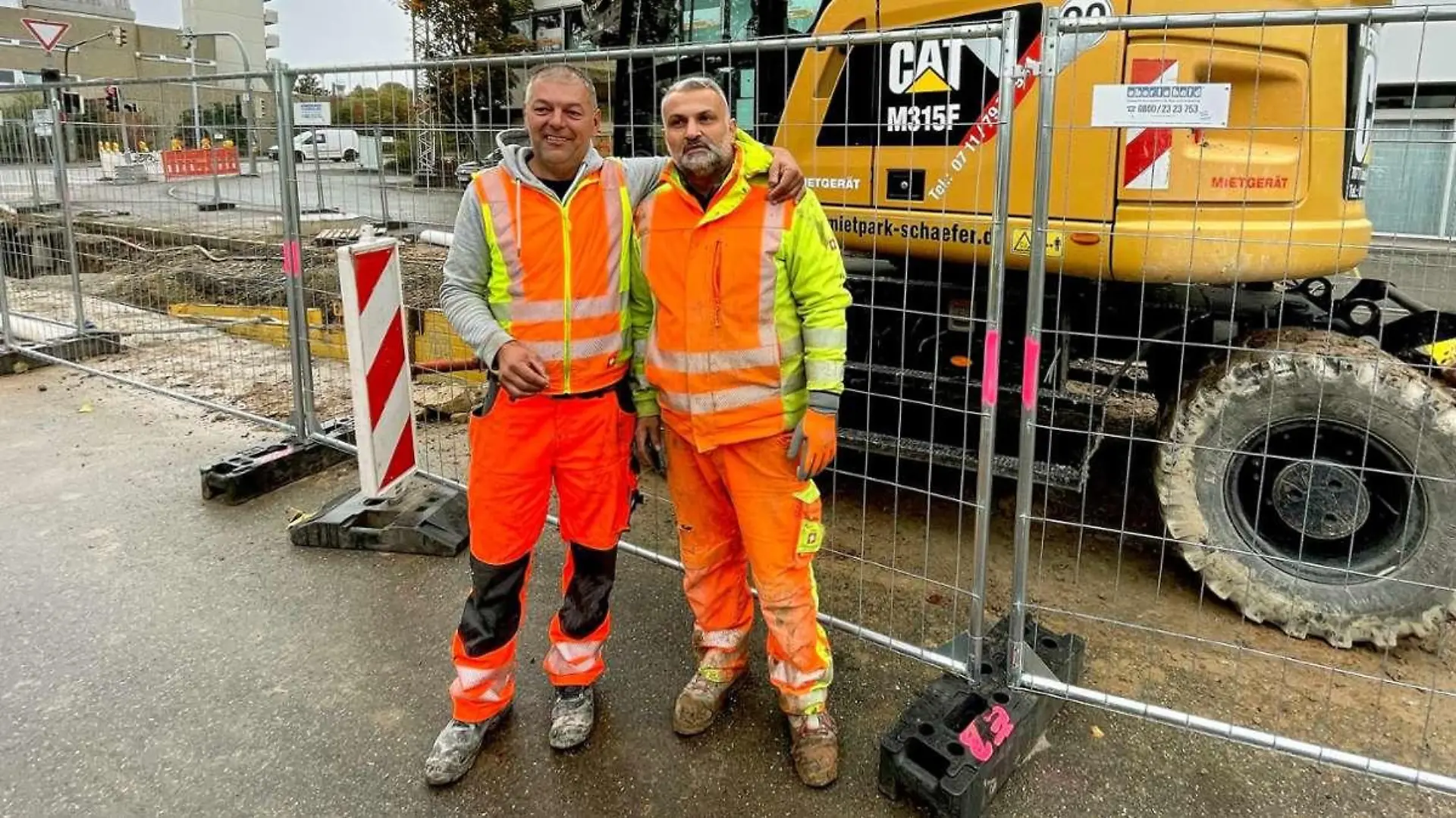 Zwei Bauarbeiter in Arbeitskleidung.