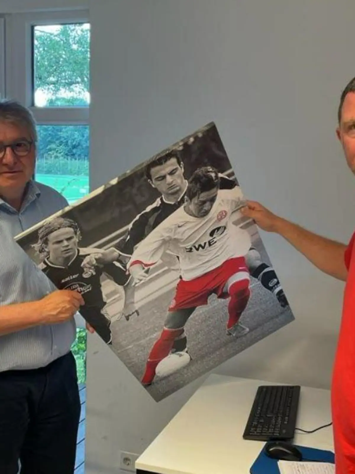 Deutliches Zeichen gegen Özil! Hier hängen Peter Renzel von der Stadt Essen und Tani Capitain von den "Essener Chancen" das Bild ab.