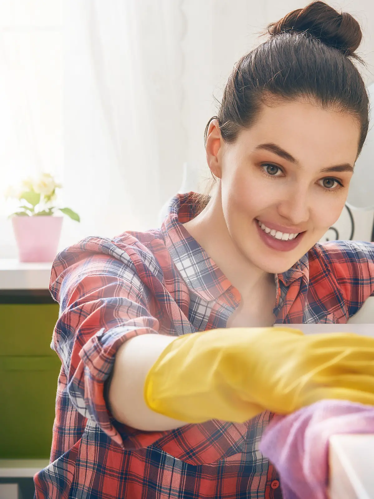 Beautiful young woman makes cleaning the house. Girl rubs dust.