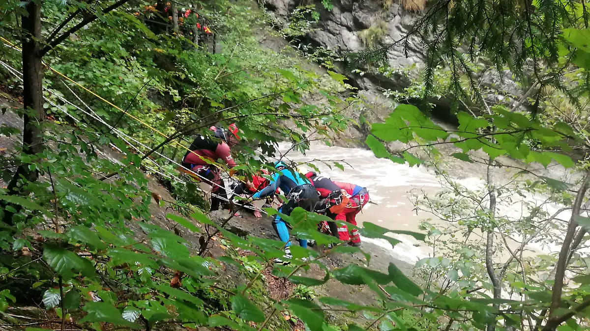 03.09.2022, Bayern, Sonthofen: Retter arbeiten an einem Steilhang am Flussufer. Eine Frau wird vermisst, nachdem ihre Gruppe beim sogenannten Canyoning in der Starzlachklamm bei Sonthofen (Landkreises Oberallgäu) von einer Sturzflut überrascht wurde. Nach einem starken Gewitter seien mehrere Sportler der Gruppe am Samstagmittag vom schnell ansteigenden Wasser eingeschlossen und teilweise mitgerissen worden. Foto: Andrea Liss/dpa +++ dpa-Bildfunk +++