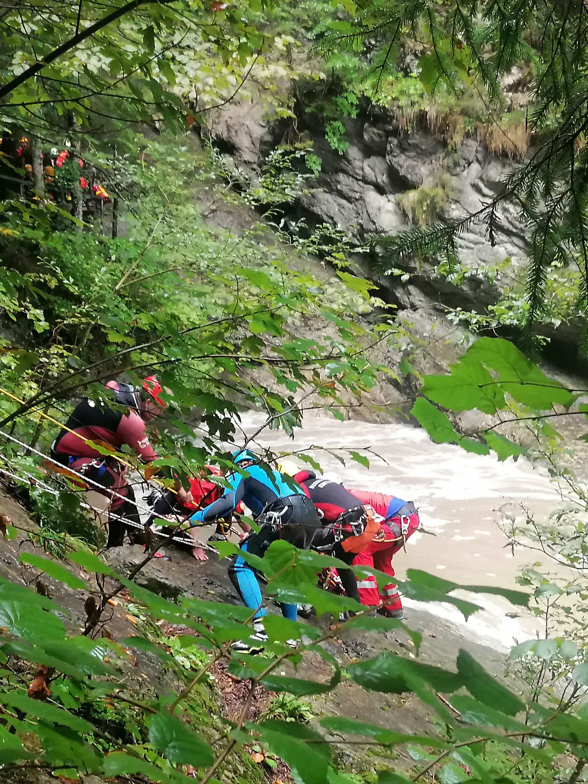 03.09.2022, Bayern, Sonthofen: Retter arbeiten an einem Steilhang am Flussufer. Eine Frau wird vermisst, nachdem ihre Gruppe beim sogenannten Canyoning in der Starzlachklamm bei Sonthofen (Landkreises Oberallgäu) von einer Sturzflut überrascht wurde. Nach einem starken Gewitter seien mehrere Sportler der Gruppe am Samstagmittag vom schnell ansteigenden Wasser eingeschlossen und teilweise mitgerissen worden. Foto: Andrea Liss/dpa +++ dpa-Bildfunk +++