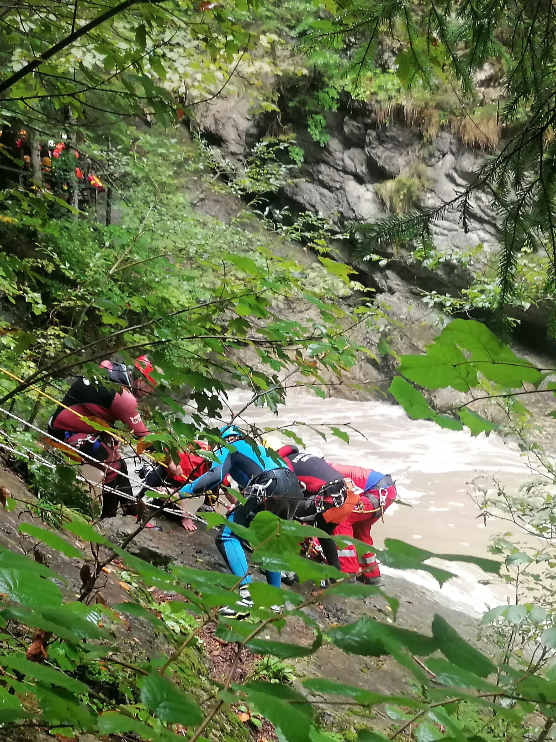 03.09.2022, Bayern, Sonthofen: Retter arbeiten an einem Steilhang am Flussufer. Eine Frau wird vermisst, nachdem ihre Gruppe beim sogenannten Canyoning in der Starzlachklamm bei Sonthofen (Landkreises Oberallgäu) von einer Sturzflut überrascht wurde. Nach einem starken Gewitter seien mehrere Sportler der Gruppe am Samstagmittag vom schnell ansteigenden Wasser eingeschlossen und teilweise mitgerissen worden. Foto: Andrea Liss/dpa +++ dpa-Bildfunk +++