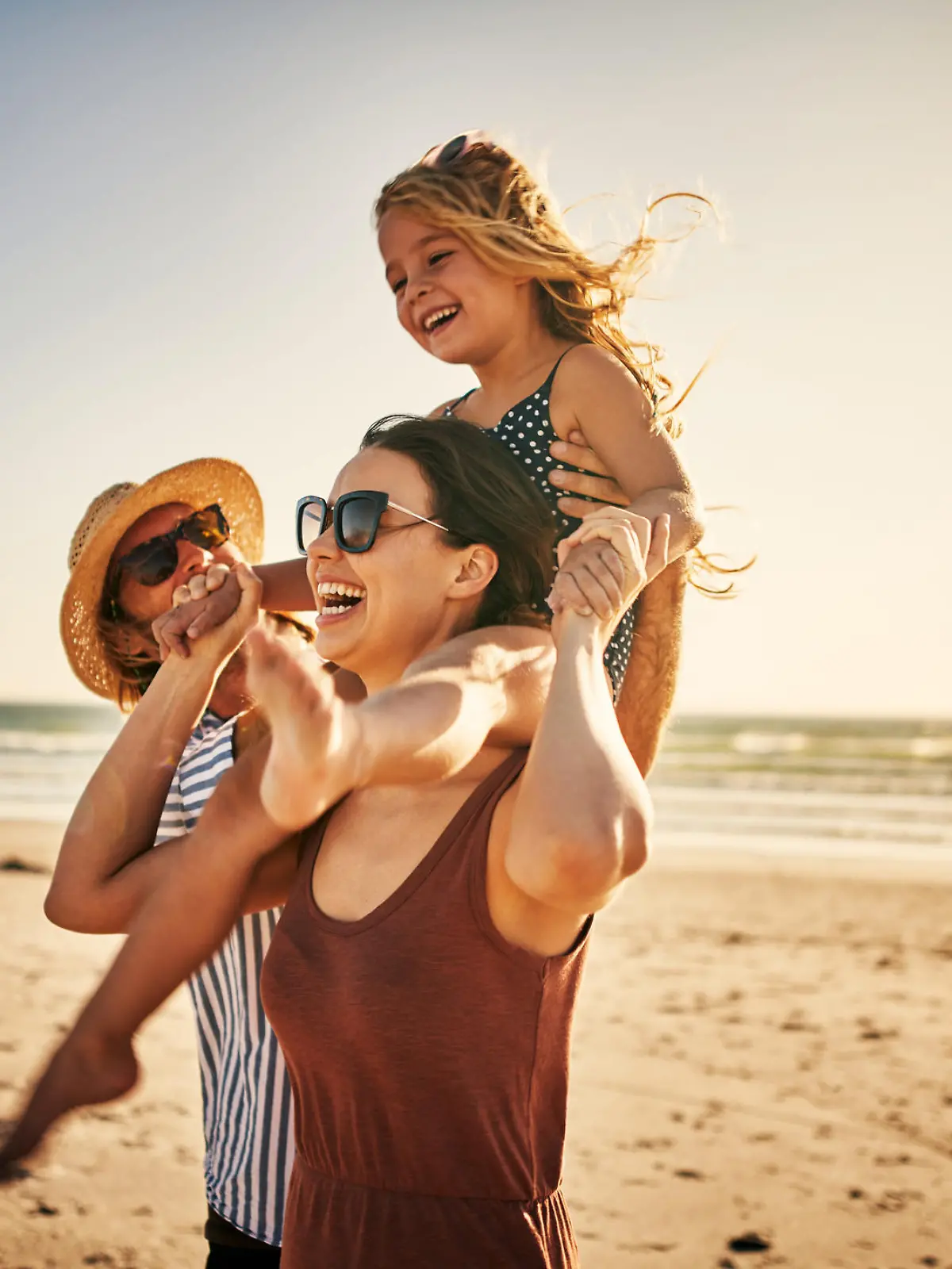 Shot of an adorable little girl spending the day at the beach with her parents