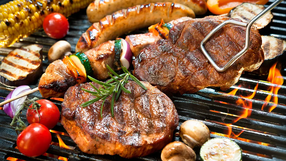 Assorted delicious grilled meat with vegetable over the coals on a barbecue