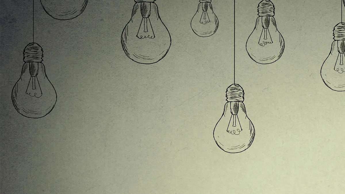 Portrait thinking woman in glasses looking up with light idea bulb above head isolated on gray wall background