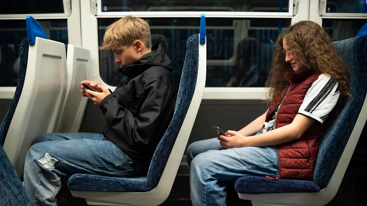 Boy and girl using smart phones sitting in train model released, Symbolfoto, NJAF00623