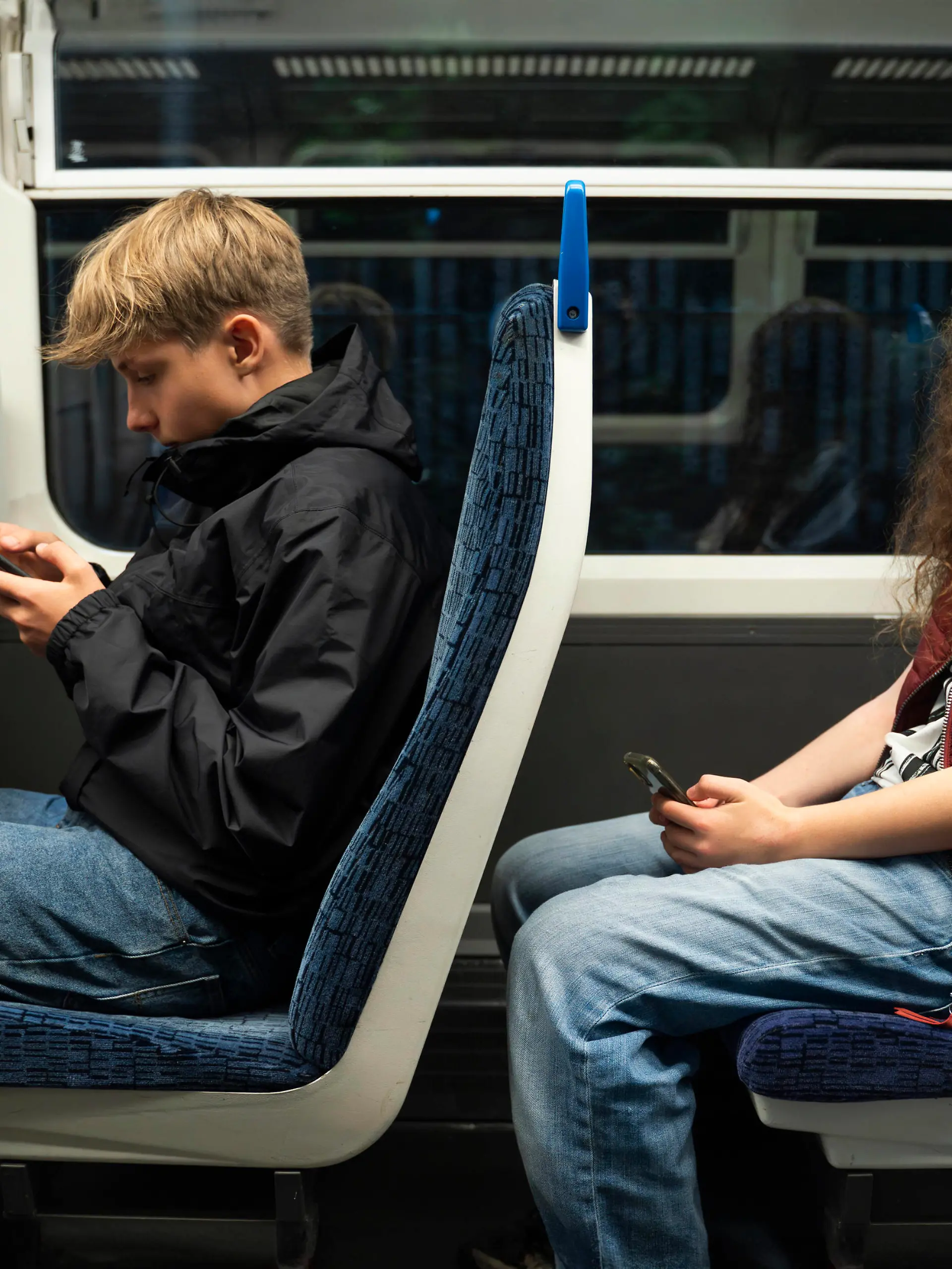 Boy and girl using smart phones sitting in train model released, Symbolfoto, NJAF00623