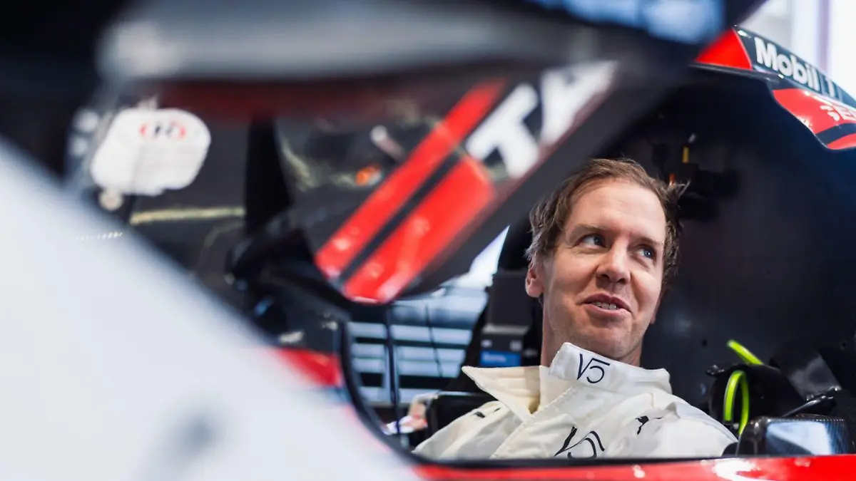 Sebastian Vettel sitzt in seinem Porsche-Rennwagen.