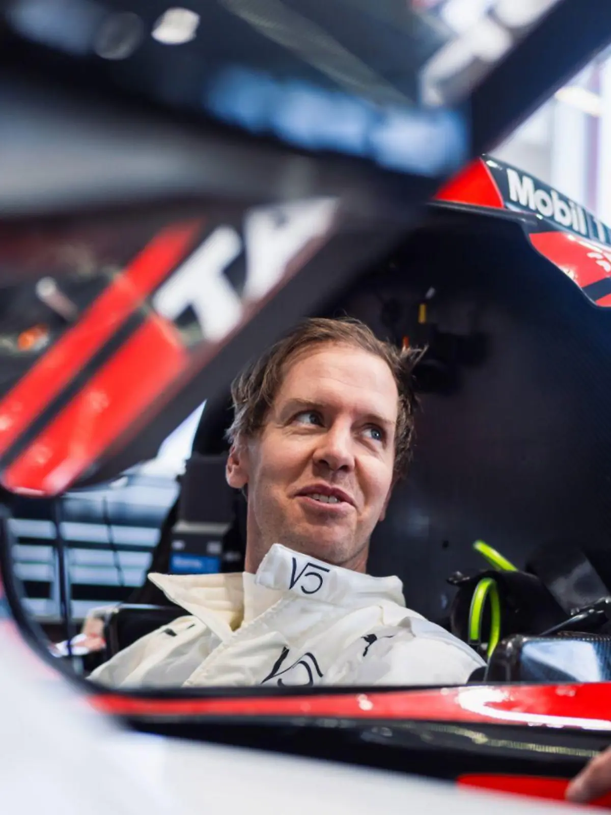 Sebastian Vettel sitzt in seinem Porsche-Rennwagen.