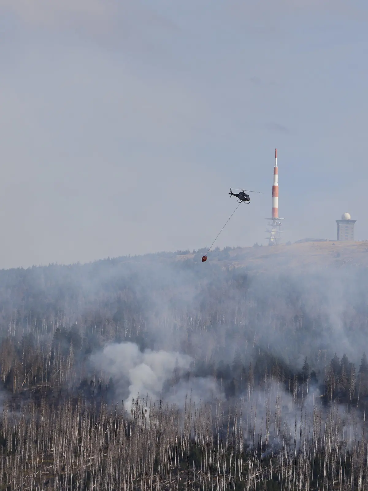 04.09.2022, Sachsen-Anhalt, Schierke: Mit Löschhubschraubern wird das Feuer am Brocken bekämpft. Insgesamt 5 Löschhubschrauber sind im Einsatz. Foto: Matthias Bein/dpa +++ dpa-Bildfunk +++