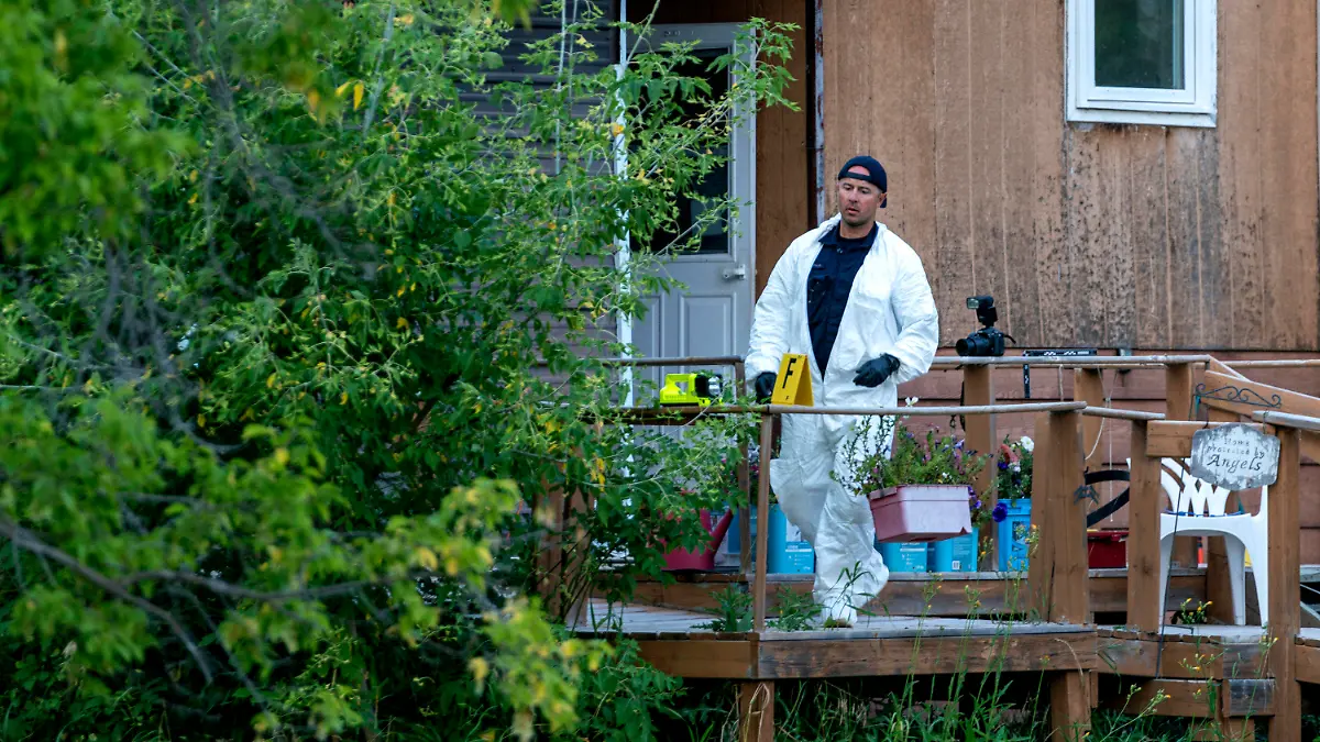 A police officer in protective gear works at the scene of a stabbing in Weldon, Saskatchewan on Sunday, Sept. 4, 2022. A series of stabbings at an Indigenous community and at another town nearby in the Canadian province of Saskatchewan left multiple people dead and others wounded, Canadian police said Sunday as they searched for two suspects. (Heywood Yu/The Canadian Press via AP)