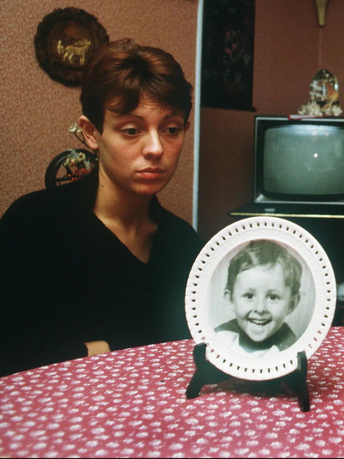 ARCHIV - 23.11.1984, Frankreich, Épinal: Christine und Jean-Marie Villemin, die Eltern des ermordeten Gregory, sitzen hinter einem Bild ihres kleinen Sohnes. Die Ermordung des damals Vierjährigen entwickelte sich zu einem der größten Justizskandale Frankreichs. (zu dpa: «Nach 40 Jahren neue Untersuchungen im Mordfall Grégory in Frankreich») Foto: Eric Feferberg/AFP/dpa +++ dpa-Bildfunk +++