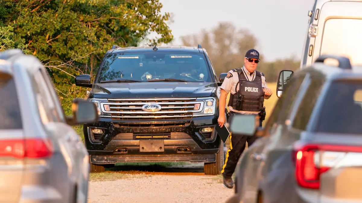 A police officer walks in a crime scene in Weldon, Saskatchewan, on Sunday, Sept. 4, 2022. Saskatchewan RCMP has confirmed that there are 10 dead while 15 are injured following the stabbings that occurred at James Smith Cree Nation and Weldon in Saskatchewan. (Heywood Yu/The Canadian Press via AP)
