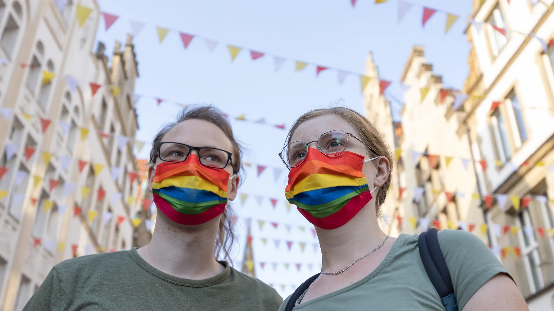 02.09.2022, Nordrhein-Westfalen, Münster: Menschen mit Mundschutz in den Farben des Regenbogens, als ein Symbol der LGBT-Bewegung, demonstrieren auf dem Prinzipalmarkt gegen Gewalt an queeren Menschen. Ein 25 Jahre alter Mann war bei einer Christopher-Street-Day-Versammlung in Münster brutal niedergeschlagen und schwer verletzt worden. Später ist er im Krankenhaus seinen Verletzungen erlegen. Der Täter ist noch nicht gestellt. Foto: Friso Gentsch/dpa +++ dpa-Bildfunk +++
