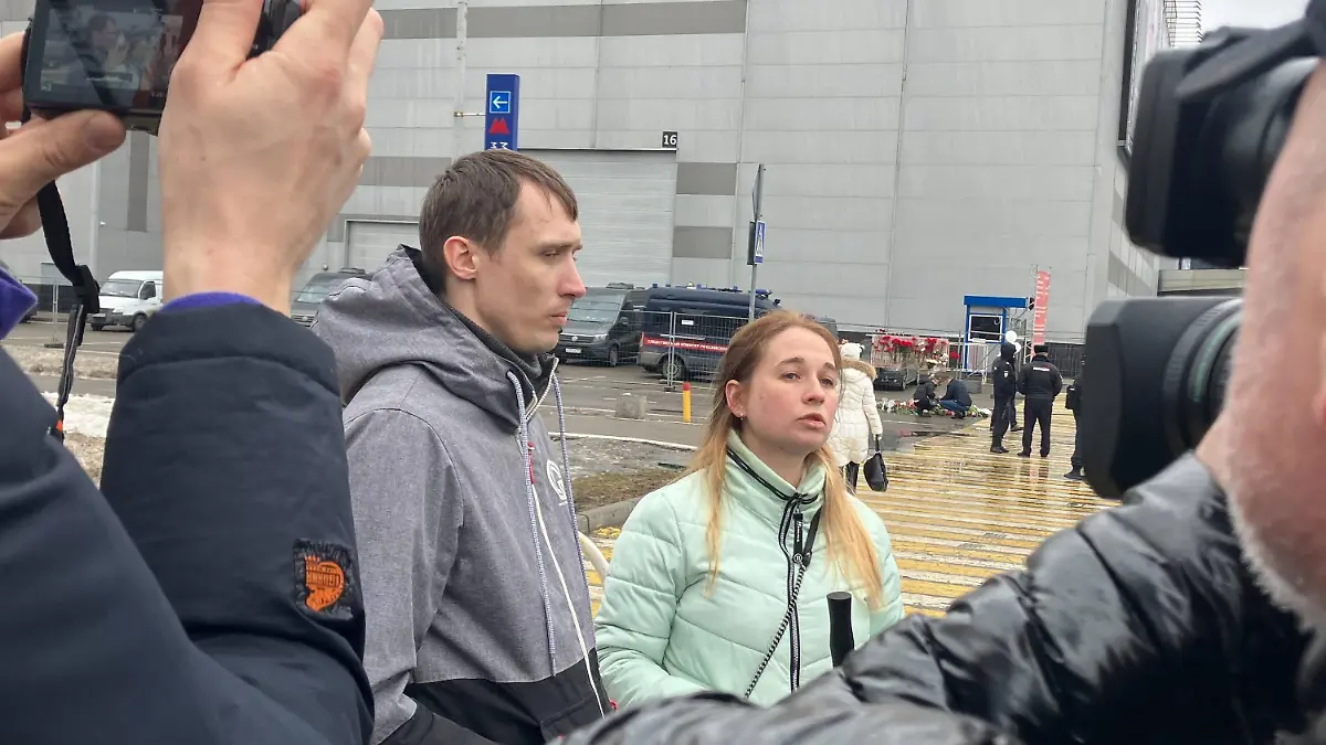 23.03.2024, Russland, Moskau: Margarita und ihr Mann Pawel geben anwesenden Medienvertretern ein Interview, unweit des Anschlagsortes. Am Tag nach dem Terroranschlag mit vielen Toten sind mehrere Überlebende zum Ort des Verbrechens zurückgekehrt, um zu trauern und Blumen abzulegen. Foto: Hannah Wagner/dpa +++ dpa-Bildfunk +++