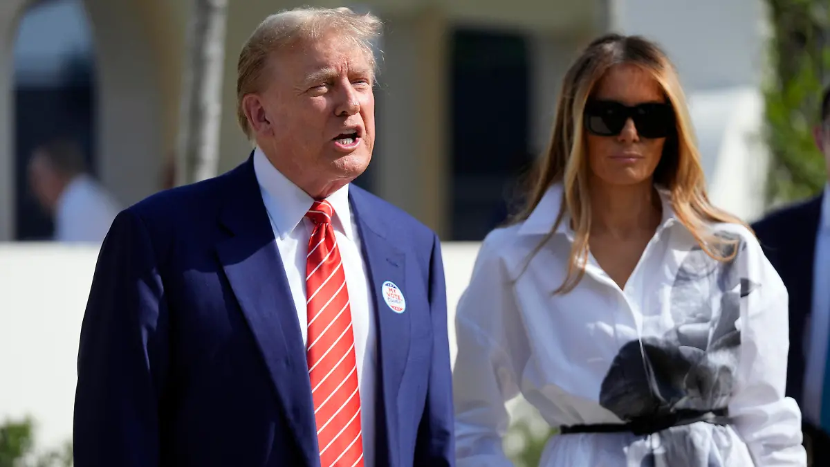 Republican presidential candidate former President Donald Trump talks as former first lady Melania Trump listens as they leave after voting in the Florida primary election in Palm Beach, Fla., Tuesday, March 19, 2024. (AP Photo/Wilfredo Lee)