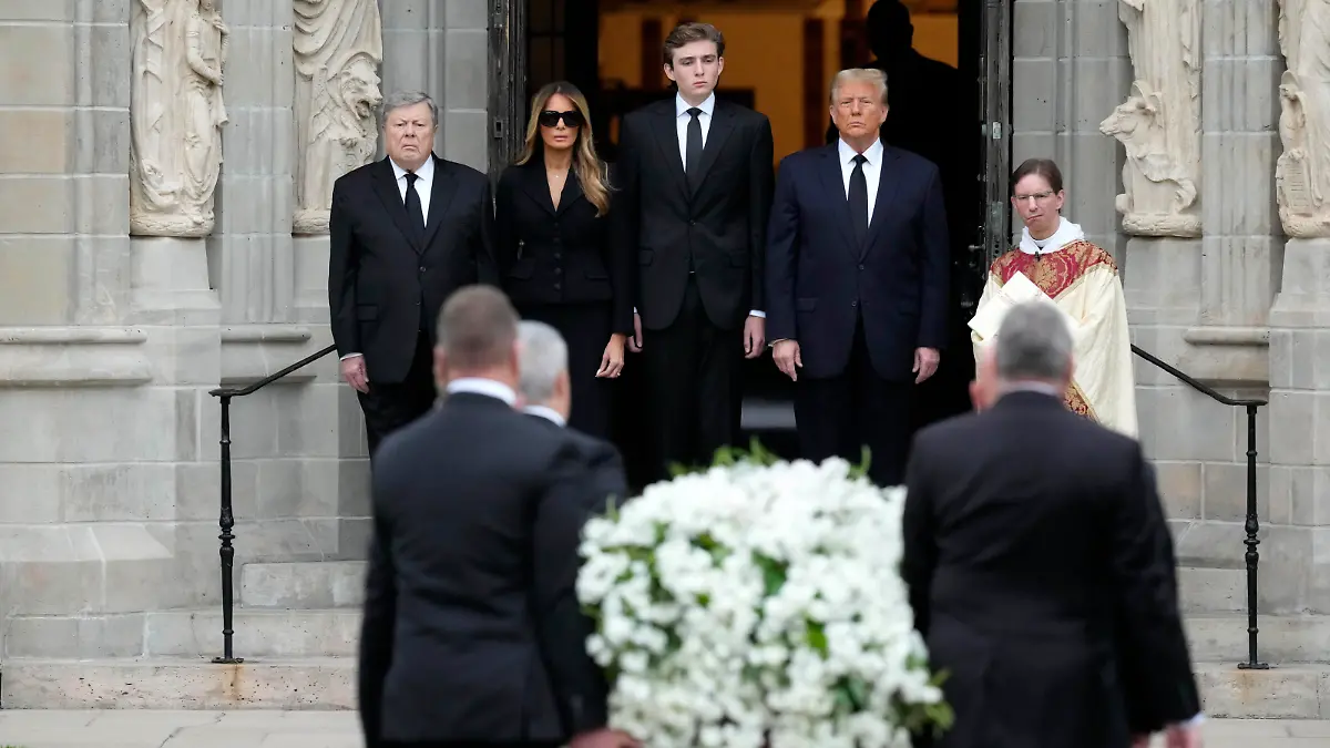 Former President Donald Trump, center right, stands with his wife Melania, second left, their son Barron, center left, and father-in-law Viktor Knavs, as the coffin carrying the remains of Amalija Knavs, the former first lady's mother, is carried into the Church of Bethesda-by-the-Sea for her funeral, in Palm Beach, Fla., Thursday, Jan. 18, 2024. (AP Photo/Rebecca Blackwell)