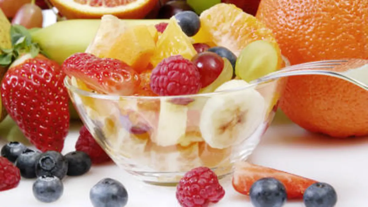 Obstsalat in einer Glasschale arrangiert mit frischen ganzen Früchten