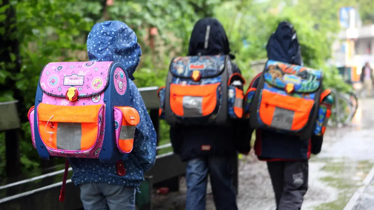  19.05.2010, Berlin, Deutschland - Kinder bei Regenwetter auf dem Weg zur Schule. QF, Rückansicht, Schüler, Grundschüler, Rücken, Haltungsschäden, Nässe, europäisch 00S100519D004.JPG MODEL RELEASE: NO, PROPERTY RELEASE: NO MR:N