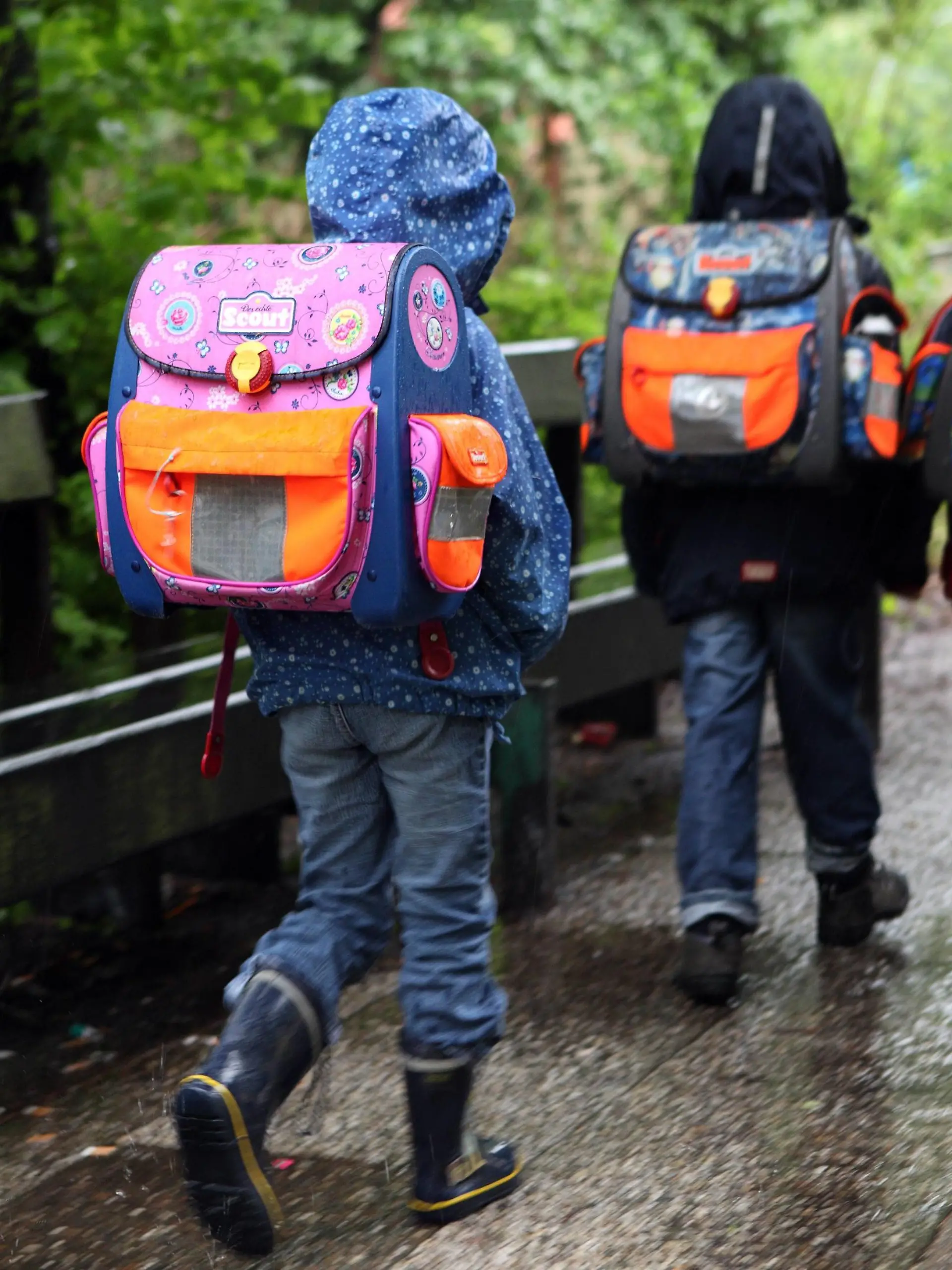  19.05.2010, Berlin, Deutschland - Kinder bei Regenwetter auf dem Weg zur Schule. QF, Rückansicht, Schüler, Grundschüler, Rücken, Haltungsschäden, Nässe, europäisch 00S100519D004.JPG MODEL RELEASE: NO, PROPERTY RELEASE: NO MR:N