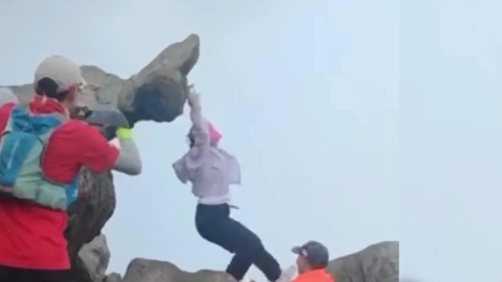 Frau baumelt plötzlich an Berggipfel