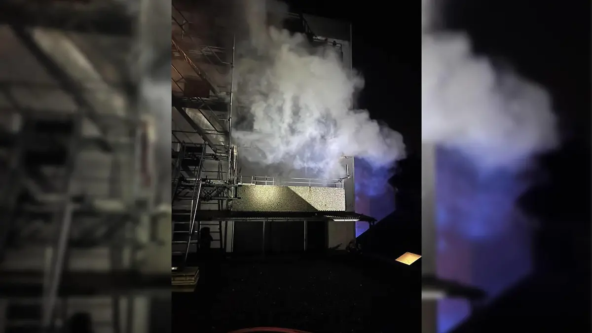 Dichter Rauch dringt bei einem Feuer in einem Wohnhaus in Erkrath aus der Gebäuderückseite heraus.