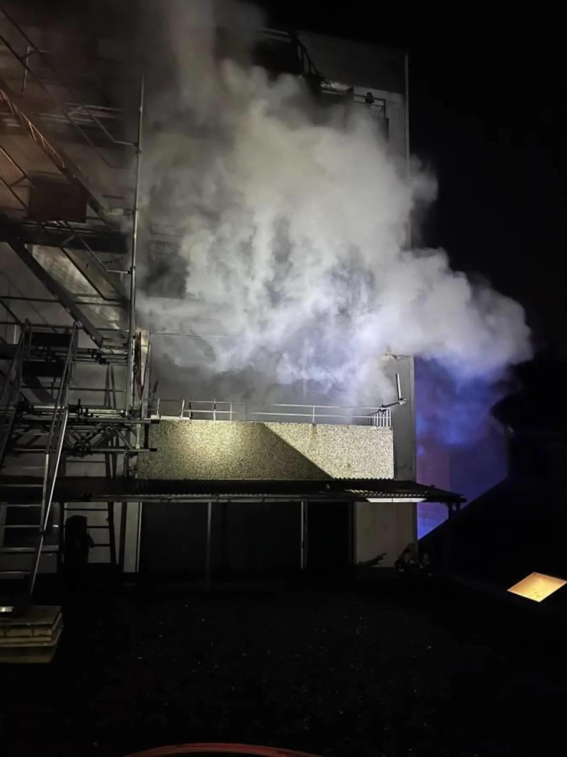 Dichter Rauch dringt bei einem Feuer in einem Wohnhaus in Erkrath aus der Gebäuderückseite heraus.