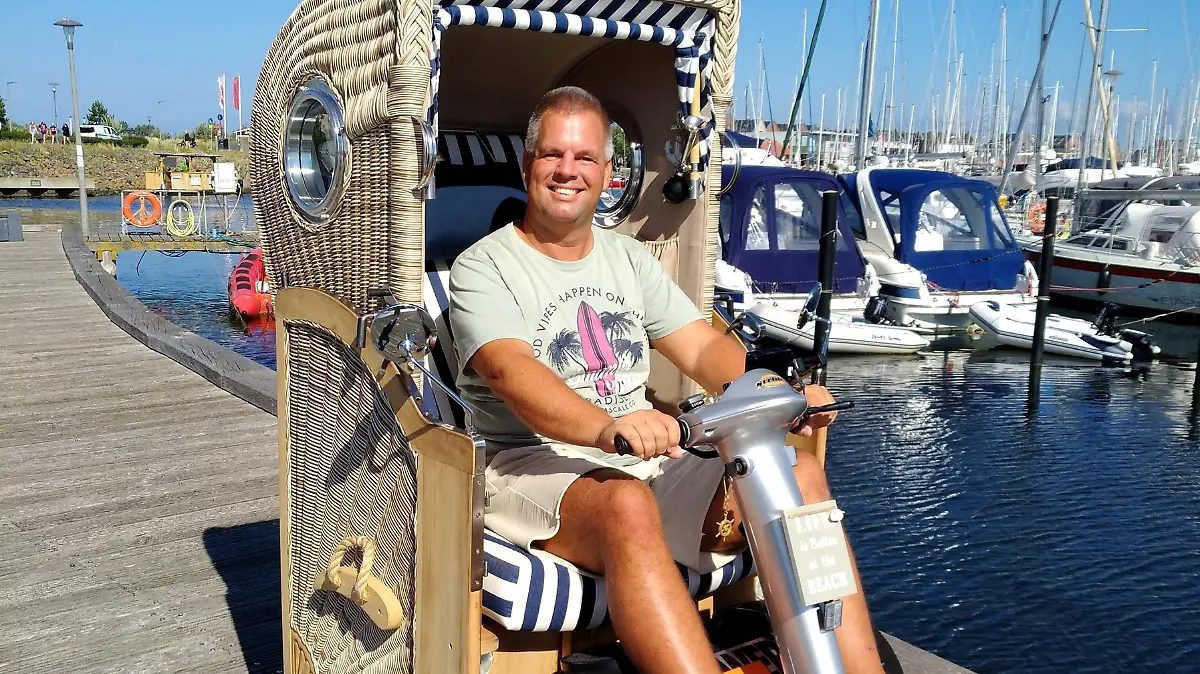 Denis Winter in seinem Strandkorb-Mobil am Yachthafen von Heiligenhafen.