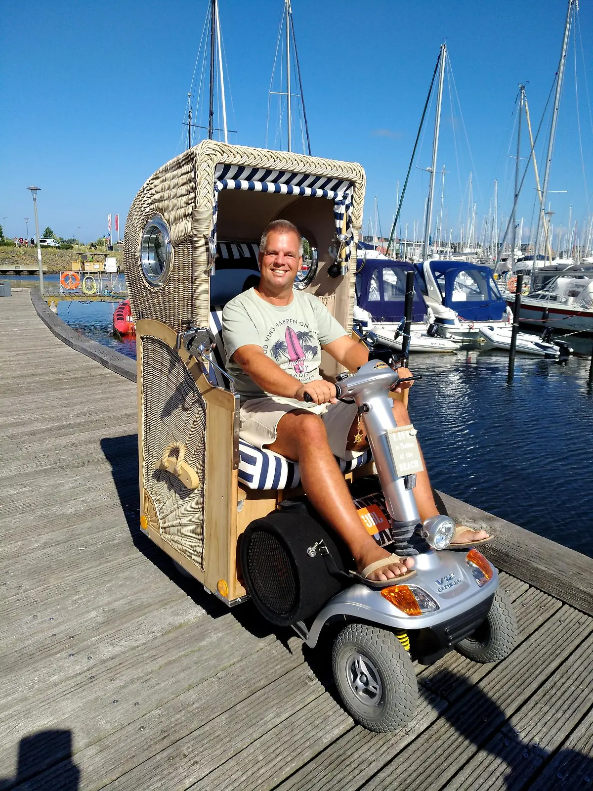 Denis Winter in seinem Strandkorb-Mobil am Yachthafen von Heiligenhafen.