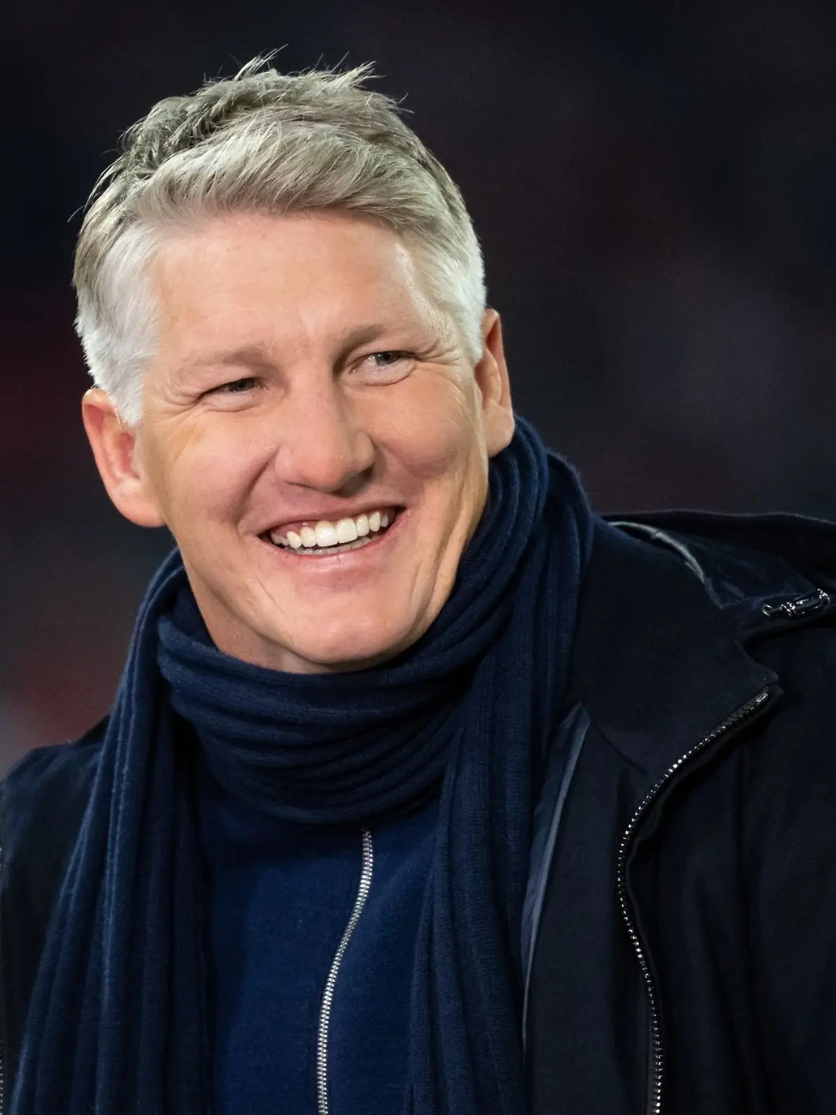 TV-Experte Bastian Schweinsteiger lacht vor einem Spiel in der Allianz Arena.