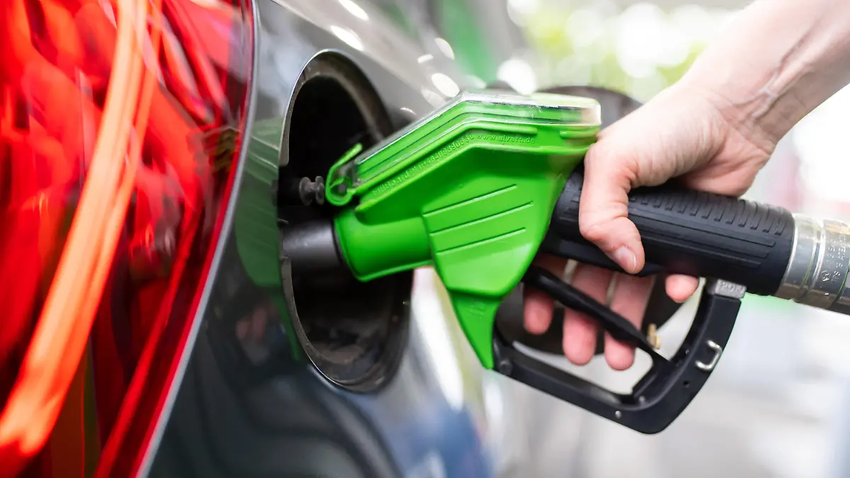 ARCHIV - 06.09.2020, Bayern, München: Eine Frau hält an einer Tankstelle an einer Zapfsäule eine Zapfpistole in der Hand und betankt ein Auto.   (zu dpa: «Kraftstoff aus Küchenresten») Foto: Sven Hoppe/dpa +++ dpa-Bildfunk +++