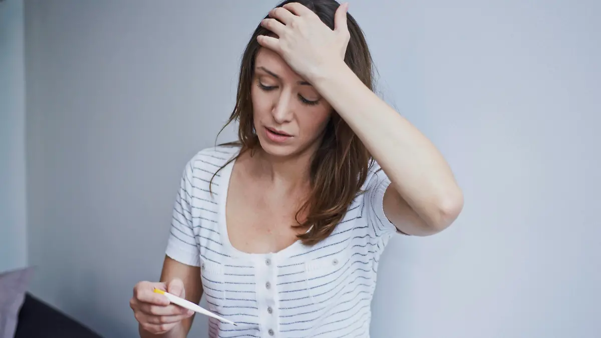 Woman checking her temperature. || Modellfreigabe vorhanden