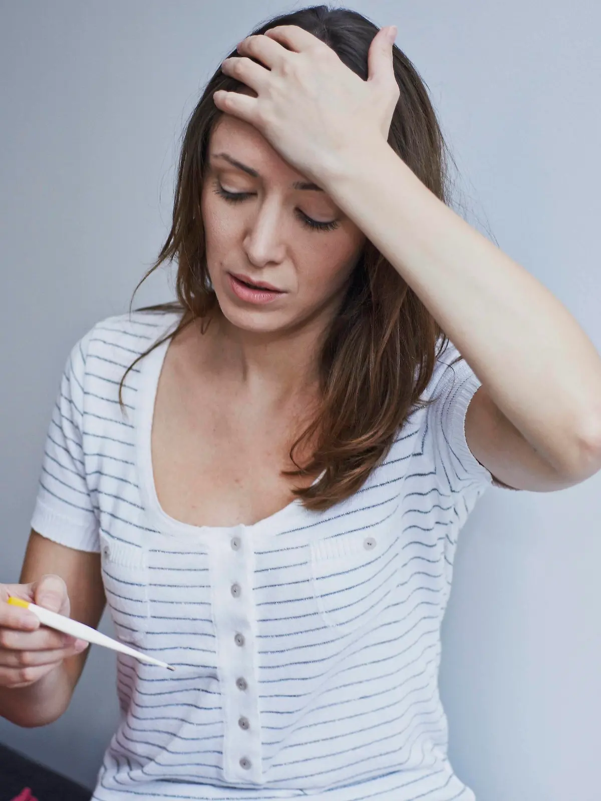Woman checking her temperature. || Modellfreigabe vorhanden